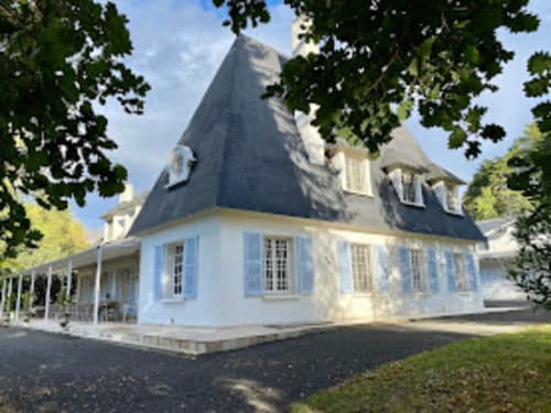 Charmantes blau-weißes Herrenhaus mit Schieferdach in Mirepoix, Ariège, umgeben von grünen Bäumen und gepflegtem Rasen