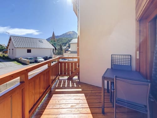Balcon en bois avec vue sur les montagnes et clocher, hébergement de la station de ski de Montgenèvre avec parking