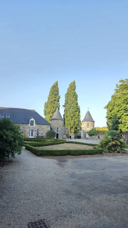 Manoir de la Bégaudière à Mont-Dol avec ses cyprès élancés, tours de pierre et haies taillées