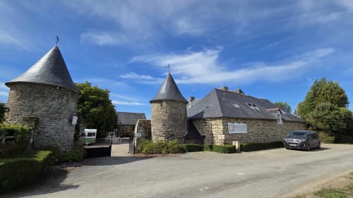 Manoir de la Bégaudière, une élégante demeure en pierre aux deux tours et toits d'ardoise à Mont-Dol, France