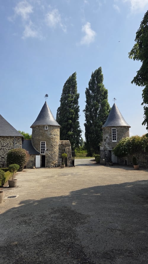 Portails d'entrée en pierre du Manoir de la Bégaudière, gîte à Mont-Dol, France, bordés de grands peupliers