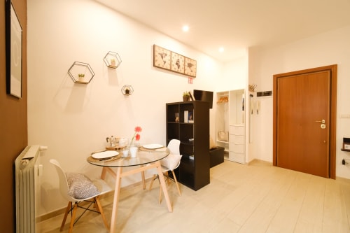 Moderno soggiorno con tavolo da pranzo, storage nero e arredamento contemporaneo presso M&D Rome Vacation vicino a San Pietro