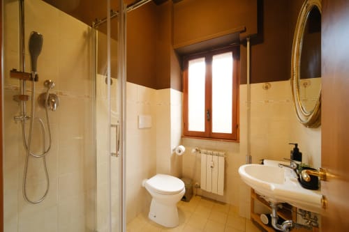 Bagno moderno con doccia walk-in, toilet, lavabo e finestra nella St Peter 83 Loft di M&D RomeVacation a Roma