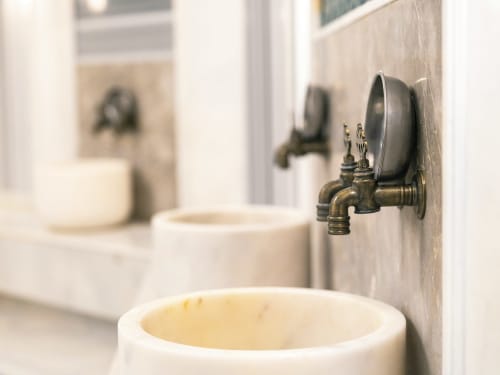 Robinet vintage en laiton à l'hôtel spa Eucalyptus Ethnic d'El Ghazouane, Maroc, avec lavabo en céramique et reflet du miroir