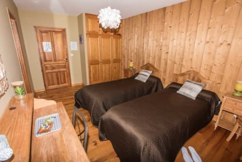 Chambre spacieuse en bois de la Maison d'hôtes Agathe Et Sophie à Lans en Vercors avec deux lits et lambris de sapin