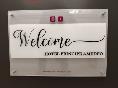 Letrero de bienvenida del Hotel Principe Amedeo con iconos de redes sociales de Instagram y Facebook