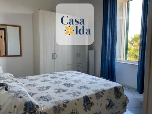 Camera luminosa a Casa Ida a Vietri con vista mare, letto matrimoniale, armadio e tende blu