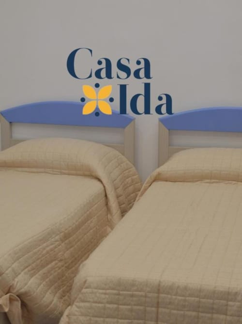 Camere Casa Ida con copriletti color crema e testiere blu con vista sul mare a Vietri, Italia