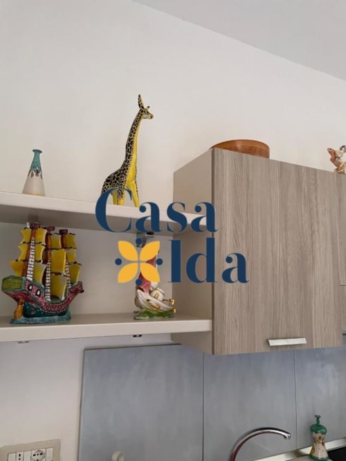 Insegna cucina Casa Ida con giraffa decorativa e ornamenti colorati su scaffali bianchi nell'appartamento di Vietri