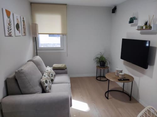 Moderna sala de estar en apartamento Casa El Abuelo, Bronchales, con sofá gris, TV de pantalla plana e iluminación natural