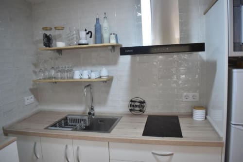 Cocina moderna en apartamento Casa El Abuelo con fregadero, estufa, encimeras de madera y azulejos blancos tipo metro