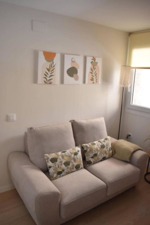Acogedora sala de estar con sofá beis y cojines decorativos en el apartamento rural Casa El Abuelo, Bronchales
