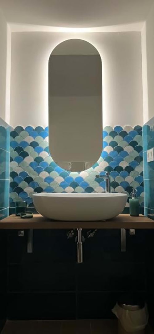Bagno moderno nella Camera Deluxe Casa Ida, Vietri con specchio ovale illuminato, lavabo bianco e piastrelle blu a conchiglia