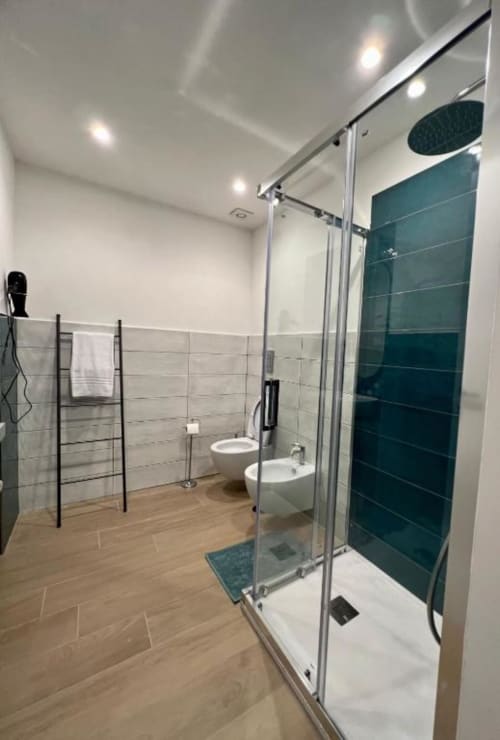 Bagno moderno nella Camera Doppia Grande di Casa Ida a Vietri, con cabina doccia in vetro, piastrelle azzurre, sanitari bianchi