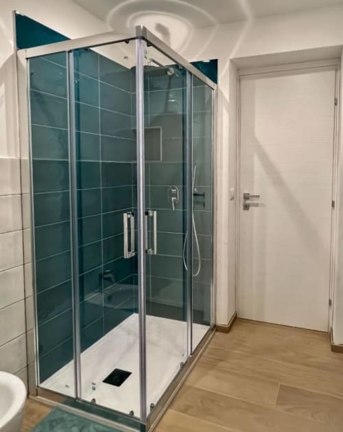Moderna doccia in vetro con rivestimento in piastrelle turchesi nella Camera Deluxe Casa Ida, Vietri