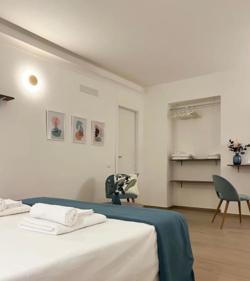 Camera moderna a Casa Ida B&B a Vietri: letto bianco, accenti turchesi, arte botanica e vista sul mare