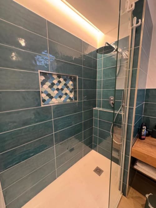 Doccia moderna con pareti in maioliche verdi e nicchia mosaicata nella Deluxe Room di Casa Ida a Vietri, Italia
