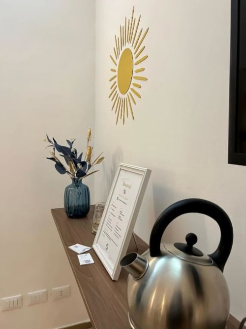 Camera Deluxe Casa Ida a Vietri con arredamento moderno, bollitore, vaso con fiori secchi, decorazione murale solare e scrivania con menu