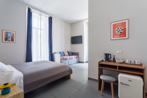 Spaziosa camera Matrimoniale Deluxe presso Darna Rooms Napoli con letto queen, TV, zona living e comfort moderni