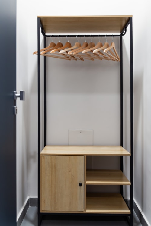 Modern wooden wardrobe with metal frame and hanging rod at Darna Rooms Naples boutique hotel