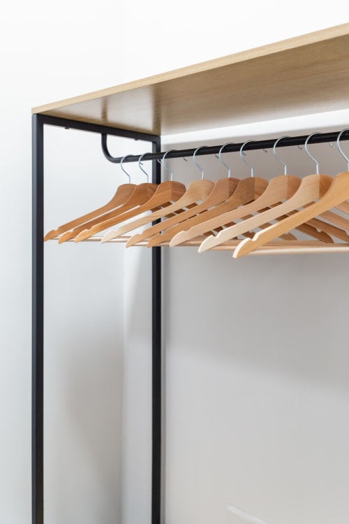 Wooden hangers on black rail at Darna Rooms, a bed and breakfast in Naples, Italy