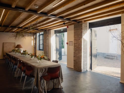 Castanea Business & Suites dining room with long table, brick columns, wooden beams, and terrace access in Merelbeke-Melle