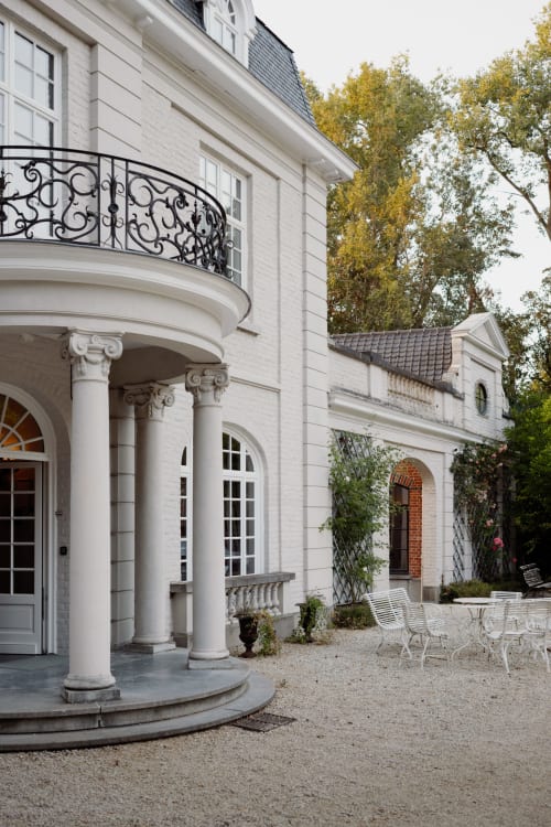Elegant white mansion exterior at Castanea Business & Suites in Merelbeke-Melle with ornate iron balcony and courtyard