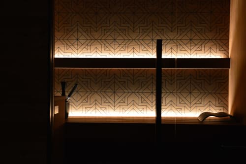 Vetrina illuminata di Villa Rosati con pannelli a motivi geometrici, elegante atmosfera notturna a Sanzeno