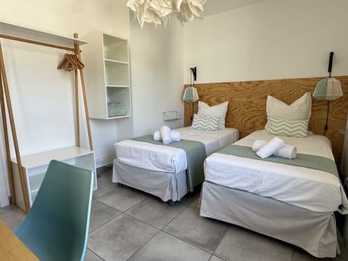 Chambre Frasso avec deux lits, vue mer, tête de lit en bois, équipements modernes à VillaSerenita Porticcio