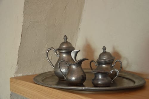 Antico servizio da tè in peltro con teiera, brocca e zuccheriera su ripiano in legno a Villa Rosati, Sanzeno