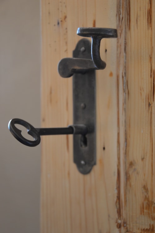 Vintage maniglia in ferro nero e serratura a chiave montate su porta in legno a Villa Rosati B&B a Sanzeno