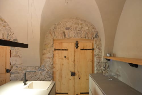 Rustica cucina in pietra con porte in legno sotto soffitto a volta a Villa Rosati a Sanzeno
