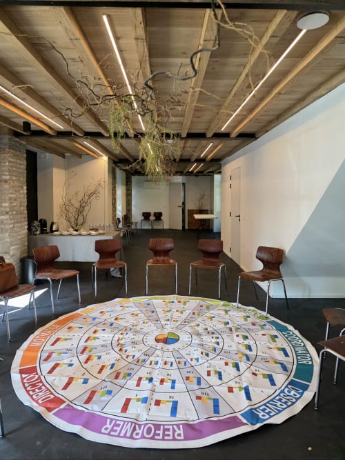 Modern conference room at Castanea Business & Suites with wooden ceiling beams, interactive floor display, and brown leather
