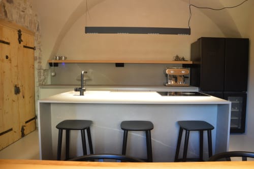 Cucina moderna di Villa Rosati B&B a Sanzeno con isola cucina, sgabelli neri e design minimalista