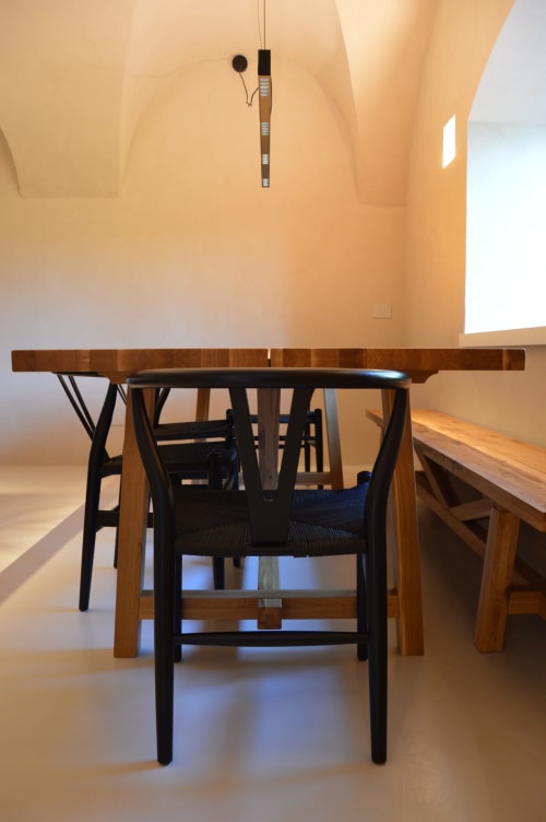 Sala da pranzo minimalista a Villa Rosati B&B a Sanzeno con tavolo in legno, sedia Wishbone nera e lucernari