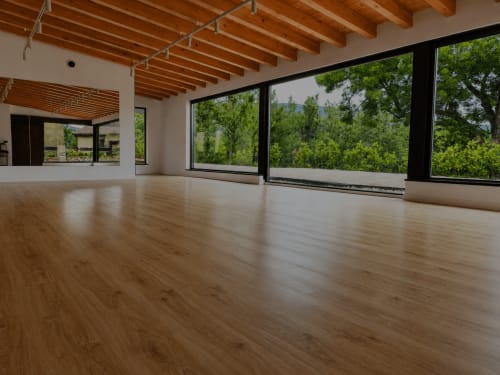 Moderno espacio para eventos con suelos de madera, vigas vistas y ventanales panorámicos con vistas al verde en Hotel Rural Izarbe, Burgos