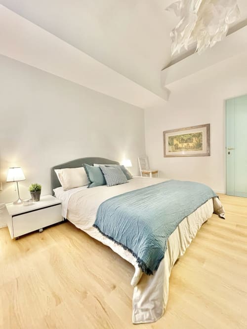 Camera da letto moderna con biancheria blu nell'appartamento Living Palazzi Storici a Bologna, pavimenti in legno e arredamento contemporaneo
