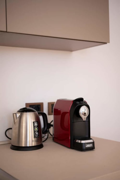 Moderni elettrodomestici in cucina nell'appartamento di Bologna - bollitore in acciaio inox e caffettiera Bialetti rossa