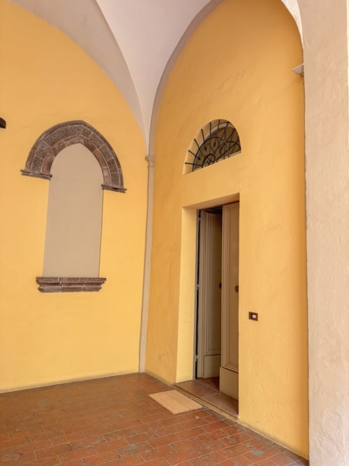Luminosa sala a volta gialla con portale ad arco nell'appartamento Living Palazzi Storici di Bologna, Italia
