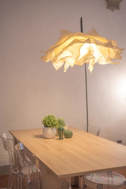 Tavolo da pranzo moderno con piante grasse sotto lampada a sospensione gialla a Living Palazzi Storici, Bologna