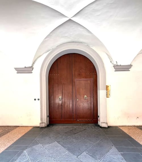 Maestoso ingresso con porta in legno ad arco presso Living Palazzi Storici, appartamento storico a Bologna, Italia