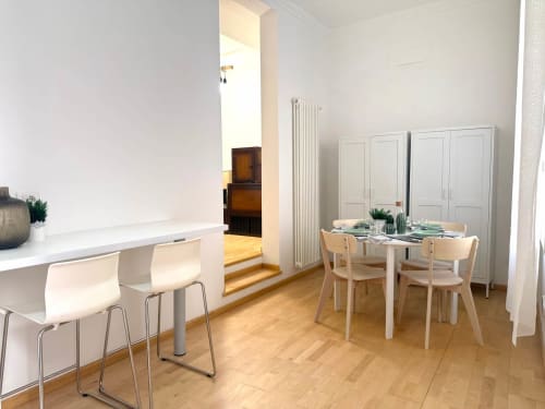Zona pranzo e cucina moderna nell'appartamento Living Palazzi Storici di Bologna, con pavimenti in legno e arredi minimalisti