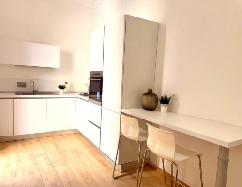 Cucina moderna bianca con banco bar nell'appartamento Living Palazzi Storici di Bologna