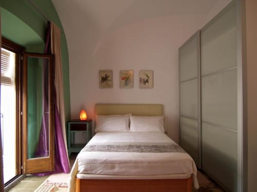 Dormitorio moderno en apartamento Plaza de Santiago, Cáceres con cama, lámpara de noche, arte floral y amplio armario