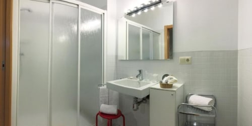 Baño moderno en apartamento Plaza de Santiago de Apartamos La Machacona, Cáceres con lavabo, espejo, ducha y