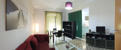 Sala de estar moderna en Cáceres con sofá rojo, comedor, escritorio y separador verde