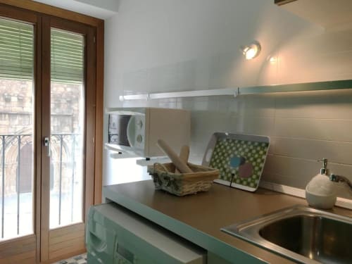 Moderna cocineta en apartamento Plaza de Santiago en Cáceres con microondas, hornilla y vista al balcón