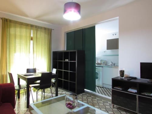 Moderno estudio en Cáceres con sala abierta, cocina americana, escritorio y muebles de almacenaje negros con detalles amarillos