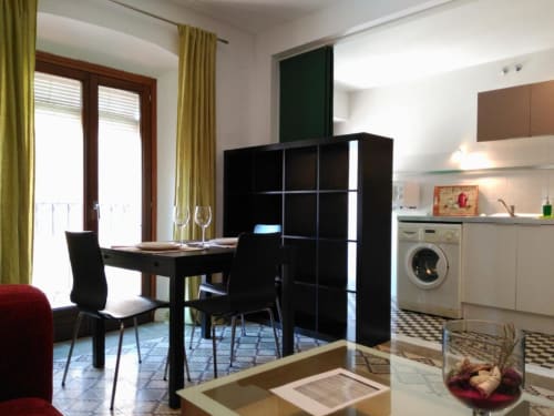 Apartamento moderno en La Machacona, Cáceres con comedor, estanterías negras, cocina con lavadora y acceso a balcón