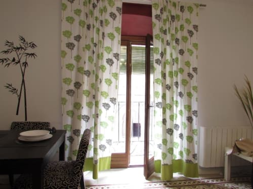 Elegante comedor en apartamento Plaza de Santiago con cortinas botánicas, mesa oscura, silla estampada y puerta de cristal